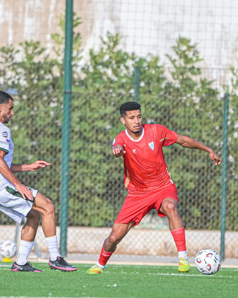 Joueur de l’IZK en rouge qui protège le ballon